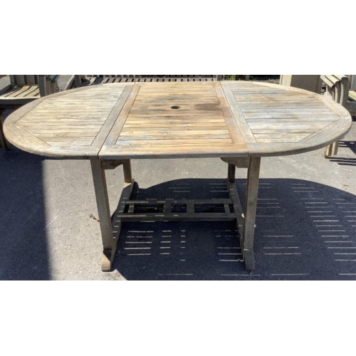 75 - Six Sherwood teak elbow chairs, a weathered teak oval extending garden table, 181cm extended, depth ... 