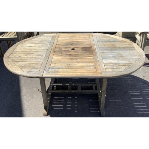75 - Six Sherwood teak elbow chairs, a weathered teak oval extending garden table, 181cm extended, depth ... 