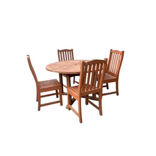 80 - A circular stained teak garden table, diameter 121cm, height 73cm and four chairs
