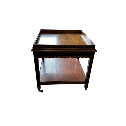 60 - An early 20th century carved walnut square two tier occasional table, with brass caps and casters, 7... 