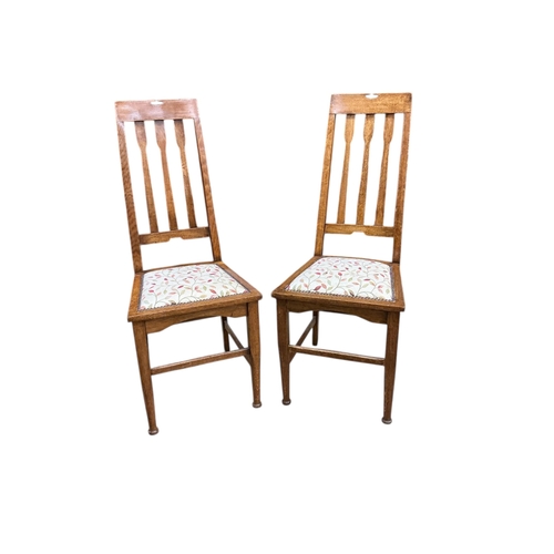 1064 - A pair of early 20th century Liberty style oak dining chairs, height 106cm