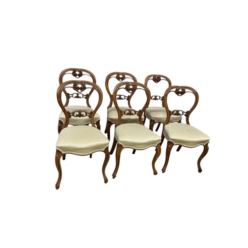 1091 - A set of six Victorian walnut balloon back dining chairs