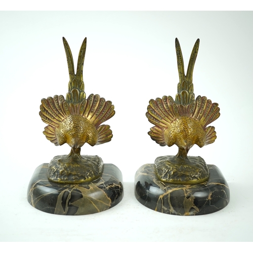 1251 - A pair of bronze peacock bookends, with remains of coloured pigments, marble plinths, signed R. Lecl... 