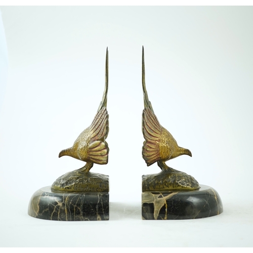 1251 - A pair of bronze peacock bookends, with remains of coloured pigments, marble plinths, signed R. Lecl... 