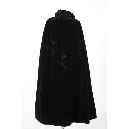 100 - An early 20th century black velvet evening cape, with a floral decorative appliqué collar and embroi... 