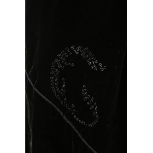 100 - An early 20th century black velvet evening cape, with a floral decorative appliqué collar and embroi... 
