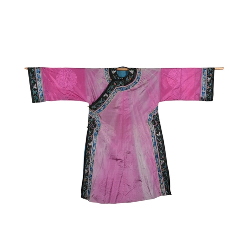111 - An early 20th century Chinese full length fuchsia coloured silk damask robe, with polychrome embroid... 