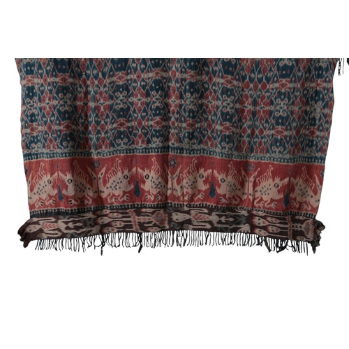 119 - An early 20th century Indonesian Sumba, hand woven and hand dyed in two narrow loom panels, in a blu... 