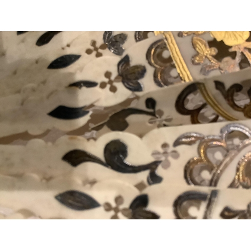 63 - A 19th century Spanish parchment and abalone fan the leaf painted with a figurative interior scene, ... 