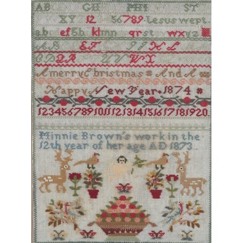 84 - A 19th century wool worked sampler by Minnie Brown, aged twelve years, dated 1873. A colourful polyc... 