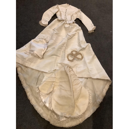 96 - A rare 1860s cream silk grosgrain wedding dress, with bustle apron, a bow attachment and floral waxe... 