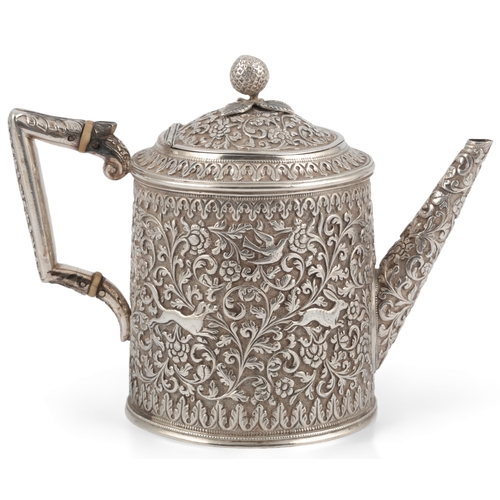 60 - A late 19th century Indian white metal three piece tea set, in the manner of Oomersee Mawjee, Bhuj, ... 