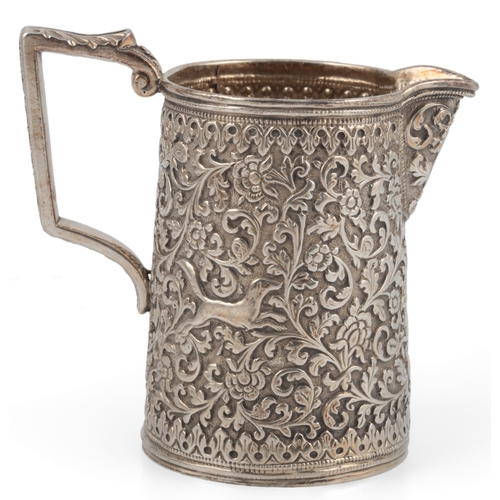 60 - A late 19th century Indian white metal three piece tea set, in the manner of Oomersee Mawjee, Bhuj, ... 