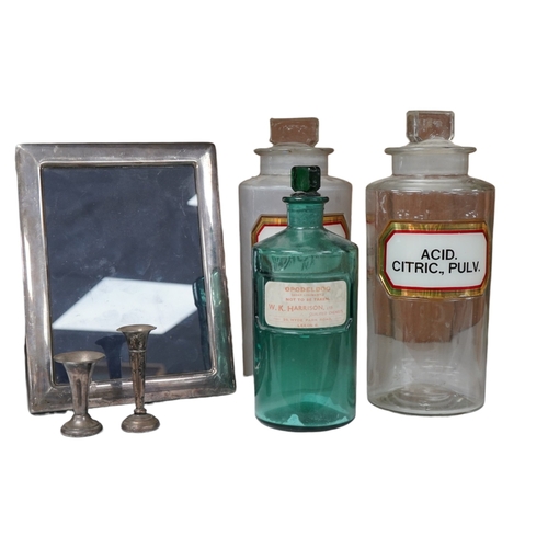 1381 - Sundry items comprising a silver mounted photo frame, two miniature silver vases, and three glass ph... 