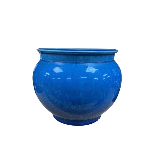 A Chinese blue glazed pottery jar of rounded form, with everted rim ...