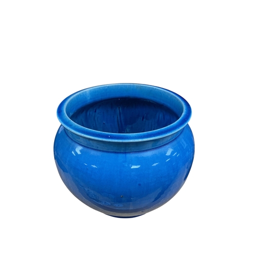A Chinese blue glazed pottery jar of rounded form, with everted rim ...