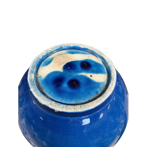 A Chinese blue glazed pottery jar of rounded form, with everted rim ...