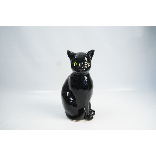 100 - A Vintage High-Gloss Ceramic Model of a Seated Black CatA ceramic figurine of a cat, depicted in a... 