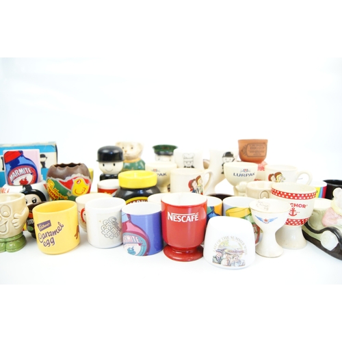 104 - A Collection of Approximately 35 Novelty and Advertising Egg Cups Featuring Various British Food and... 