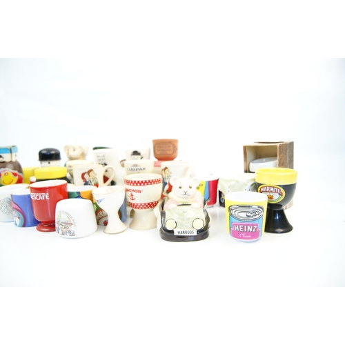 104 - A Collection of Approximately 35 Novelty and Advertising Egg Cups Featuring Various British Food and... 