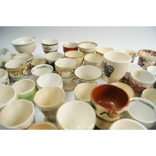 63 - A Collection of Miscellaneous Glazed Ceramic, Porcelain, and Earthenware Egg CupsA large and varie... 