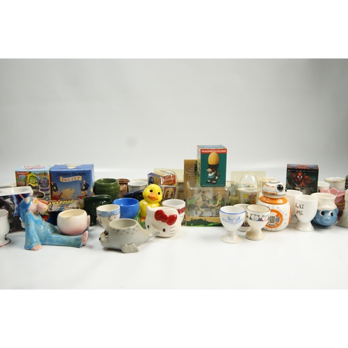 67 - A Collection of Novelty and Character-Themed Ceramic Egg CupsA varied collection of ceramic egg cu... 