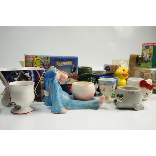 67 - A Collection of Novelty and Character-Themed Ceramic Egg CupsA varied collection of ceramic egg cu... 