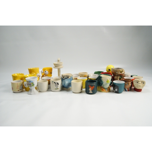 69 - A Collection of Novelty and Character Ceramic Egg CupsA varied collection of novelty egg cups cons... 