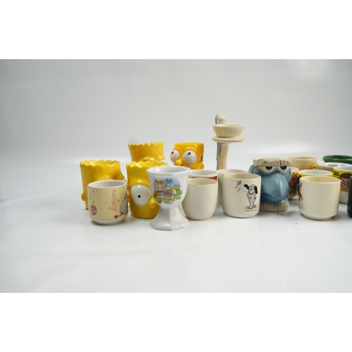 69 - A Collection of Novelty and Character Ceramic Egg CupsA varied collection of novelty egg cups cons... 
