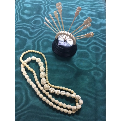 85 - A long string of carved ivory beads
and a set of ten carved ivory sticks -