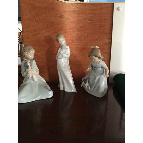 115 - A group of three Nao figures,
each of a girl playing with an animal -