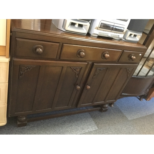 358 - A 1930's oak sideboard,
with three drawers over cupboard doors, on bun feet -