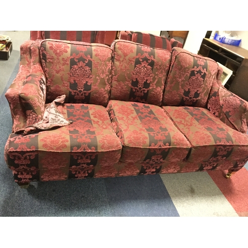 372 - A modern three piece suite,
upholstered in burgundy stripes and floral damask style upholstery, on c... 