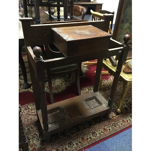 391 - An early 20th century oak hall stand,
with central lift top glove box, framed by stick stands -