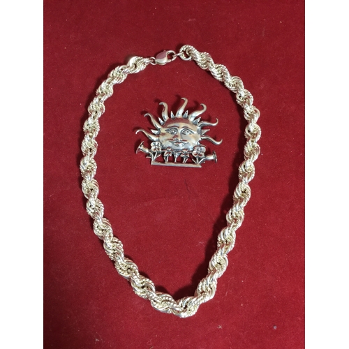 31 - A heavy silver twisted link chain, 
together with a silver sun brooch signed H & H De Matteo -