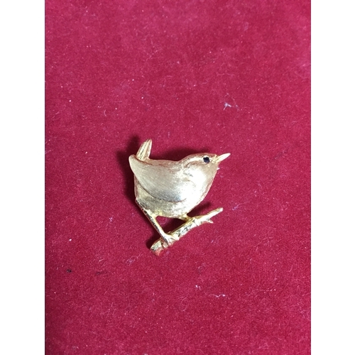 50 - A pretty 9ct gold brooch, 
modelled as a wren on a branch, with sapphire set eye -