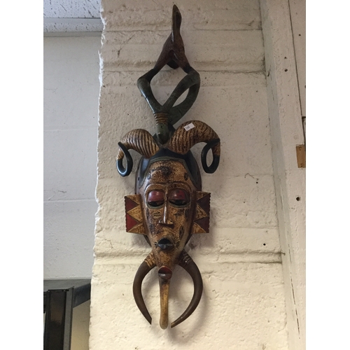 208 - Two vintage wall masks,
together with a tribal carving and another mask -