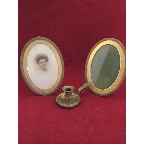 229 - A pair of brass photograph frames, 
each with easel back, and a brass chamberstick -