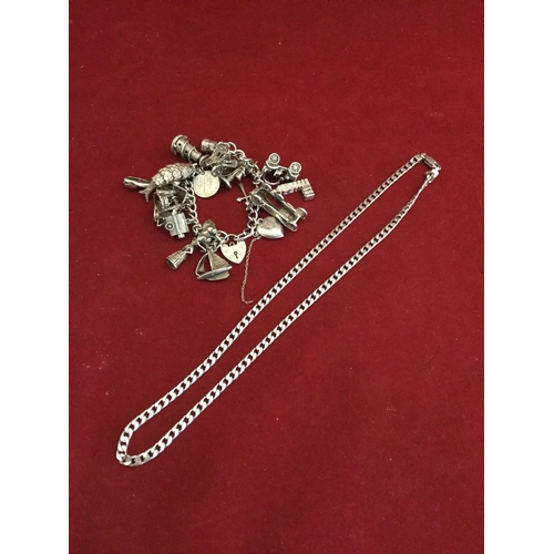 74 - A vintage silver charm bracelet, 
suspending assorted silver charms and a silver chain -