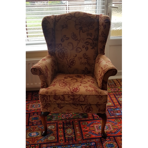 248 - A pair of Parker Knoll armchairs, 
wingbacked and on short cabriole legs -