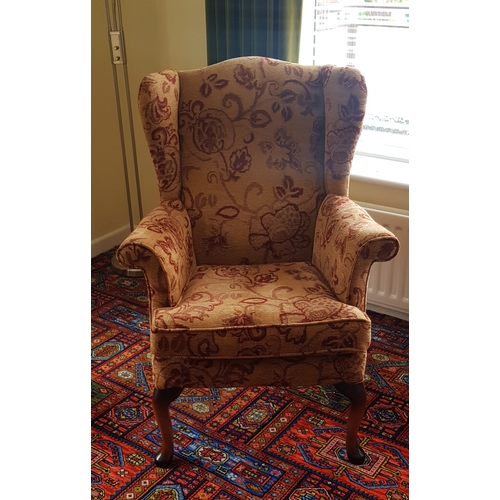 248 - A pair of Parker Knoll armchairs, 
wingbacked and on short cabriole legs -