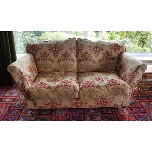 249 - A two seater settee and matching armchair, 
upholstered with loose cushions, on casters -