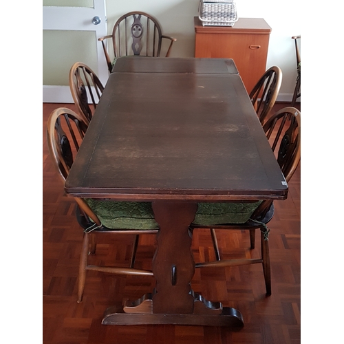 254 - An Ercol extending dining table, 
together with six Windsor type chairs with Prince of Wales feather... 