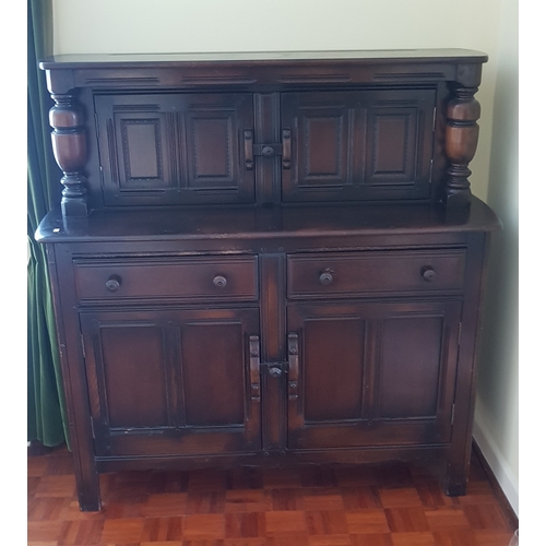 255 - An Ercol court cupboard, 
of small size, with pair of cupboard doors over two drawers and cupboard d... 