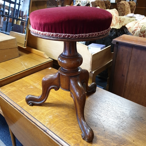 258 - A 19th century walnut framed piano stool, 
with circular adjustable seat, on central support and thr... 