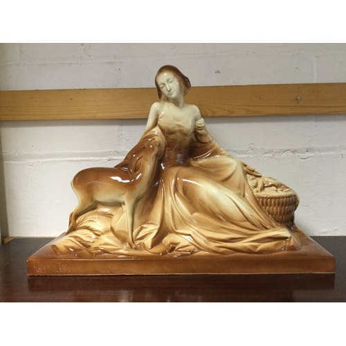 126 - A brown and cream glazed model of a lady and deer -