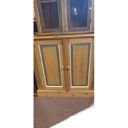 331 - A pine two door cupboard, with painted doors enclosing shelves -