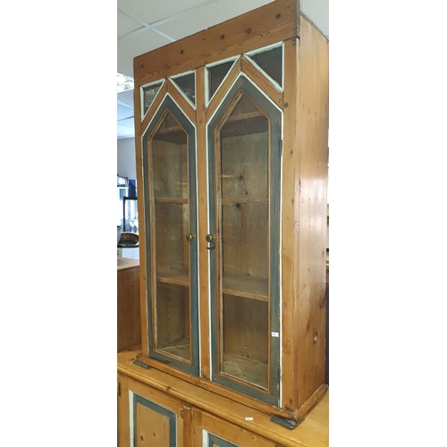 332 - A pine wall hanging cabinet, with painted detail and two glazed doors enclosing fixed shelves -