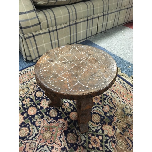 333 - A carved stool, inlaid with shell/beadwork to seat, on carved legs -