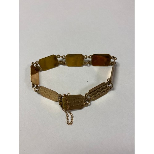 23 - A 9ct gold bracelet, composed of engine turned panel links -